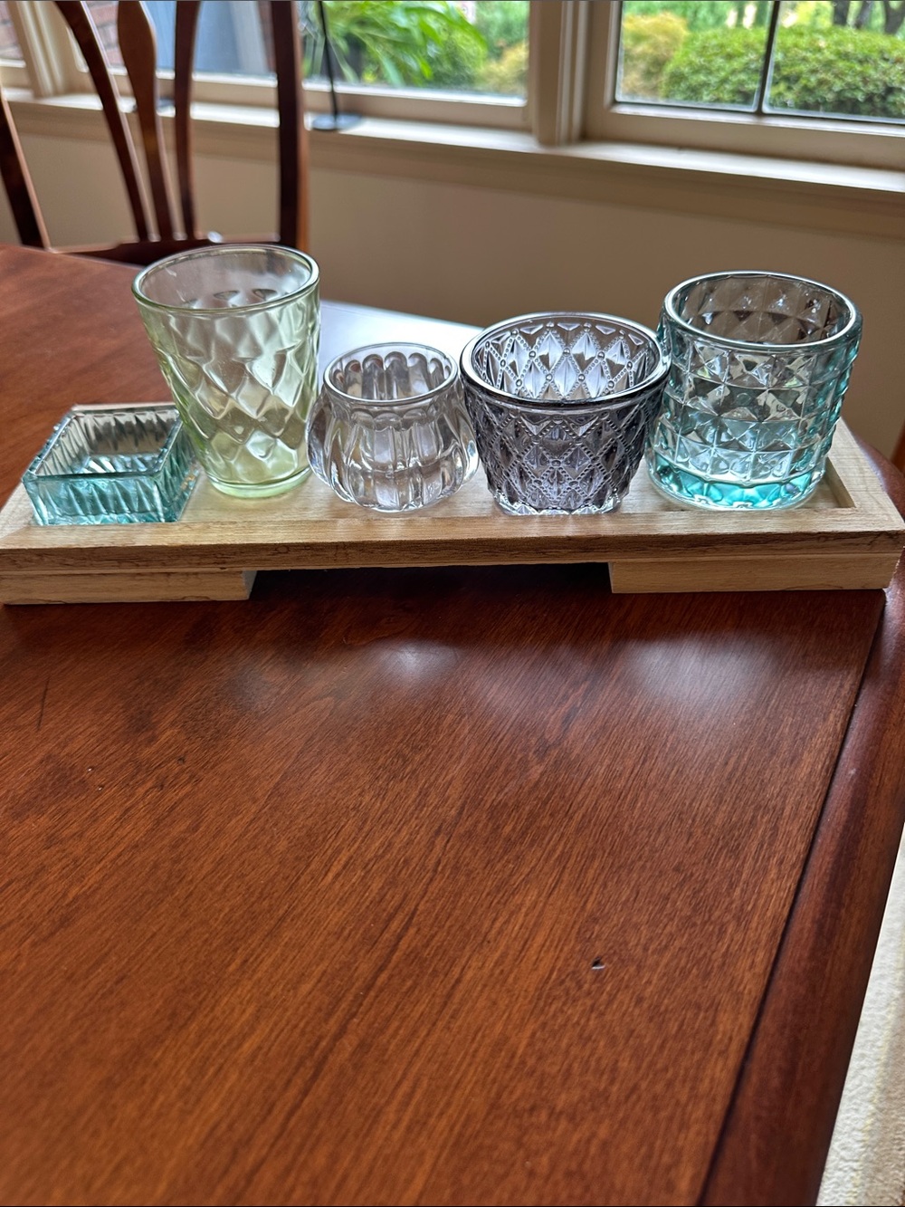 Colorful Glass Votive Set - Blue, Green, Smoke, Clear on a wooden tray.